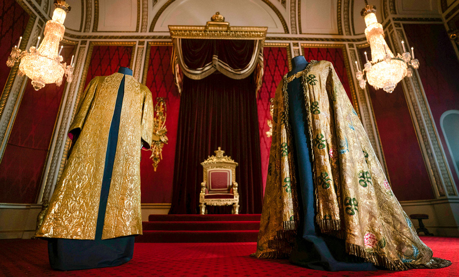 The Coronation Vestments, comprising of the Supertunica, left and the Imperial Mantle are displayed in the Throne Room at Buckingham Palace, London, Wednesday, April 26, 2023. The vestments will be worn by King Charles III during his coronation at Westminster Abbey on May 6. (Victoria Jones/PA via AP)