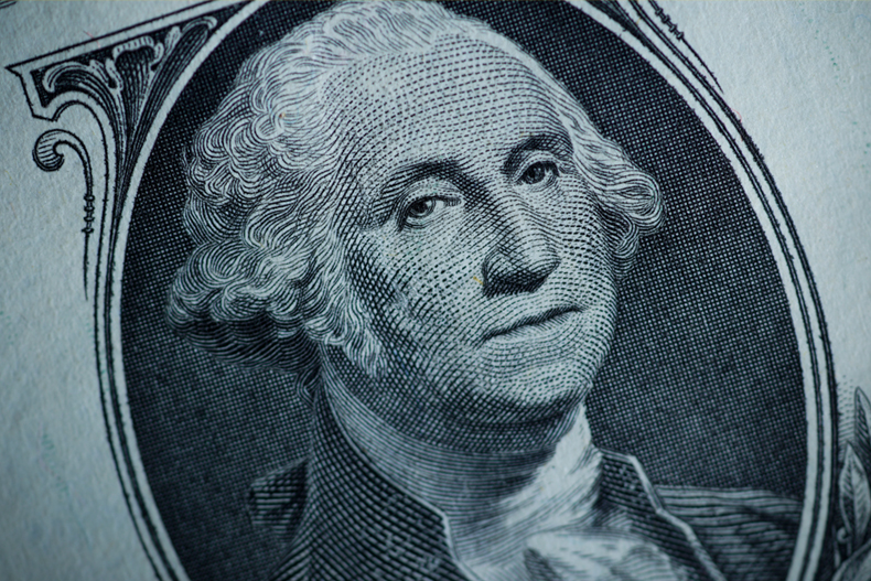 The likeness of George Washington is seen on a U.S. one dollar bill, Monday, March 13, 2023, in Marple Township, Pa. Fitch Ratings has downgraded the United States government's credit rating, citing rising debt at the federal, state, and local levels and a "steady deterioration in standards of governance" over the past two decades. (AP Photo/Matt Slocum)