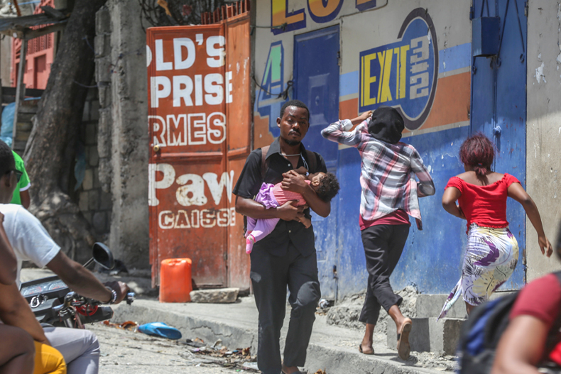 Residents flee their homes to escape clashes between armed gangs in the Carrefour-Feuilles district of Port-au-Prince, Haiti, Tuesday, Aug. 15, 2023. (AP Photo/Odelyn Joseph)