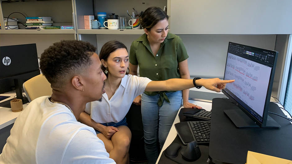 Lynée Turek-Hankins, center, points to a graph showing temperature fluctuations inside of a Miami-Dade household, as Nkosi Muse, left, and Myra Cruz look on.