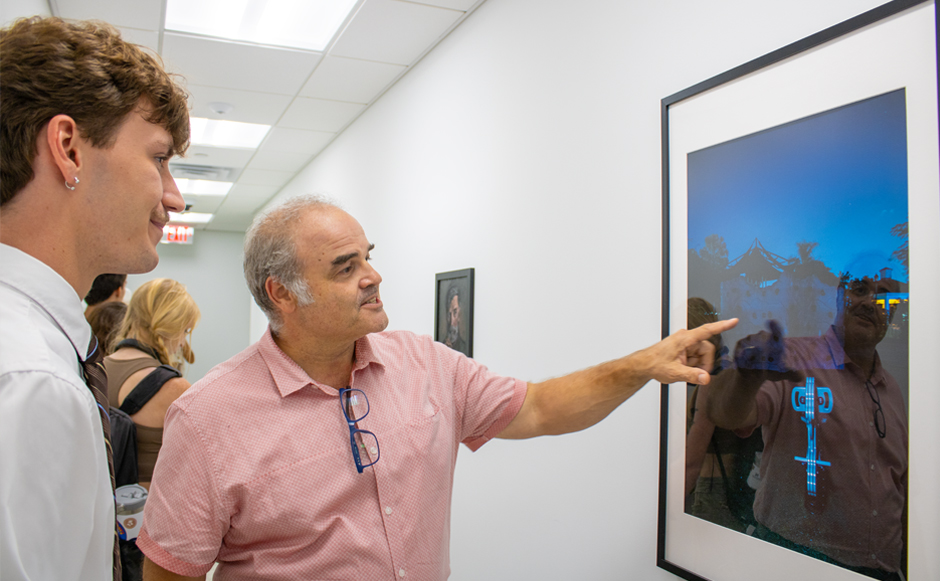 Xavier Cortada with a student at the Undergraduate Student Art Exhibition. Photo: Bianca Sproul for University of Miami