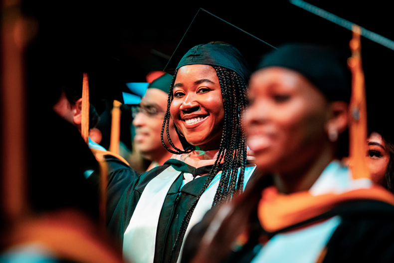 A graduate student smiles during the 10 a.m. Graduate ceremonies