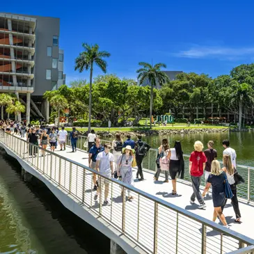 Students walk across the Fate Bridge on the Coral Gables Campus 