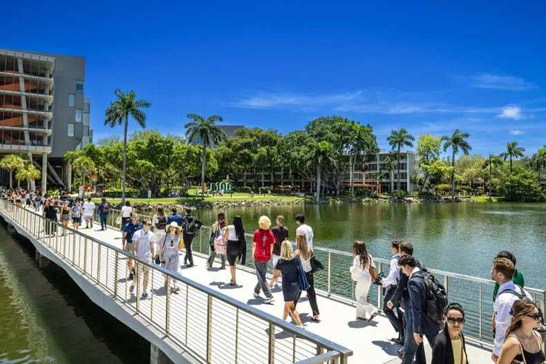 Students walk across the Fate Bridge on the Coral Gables Campus 