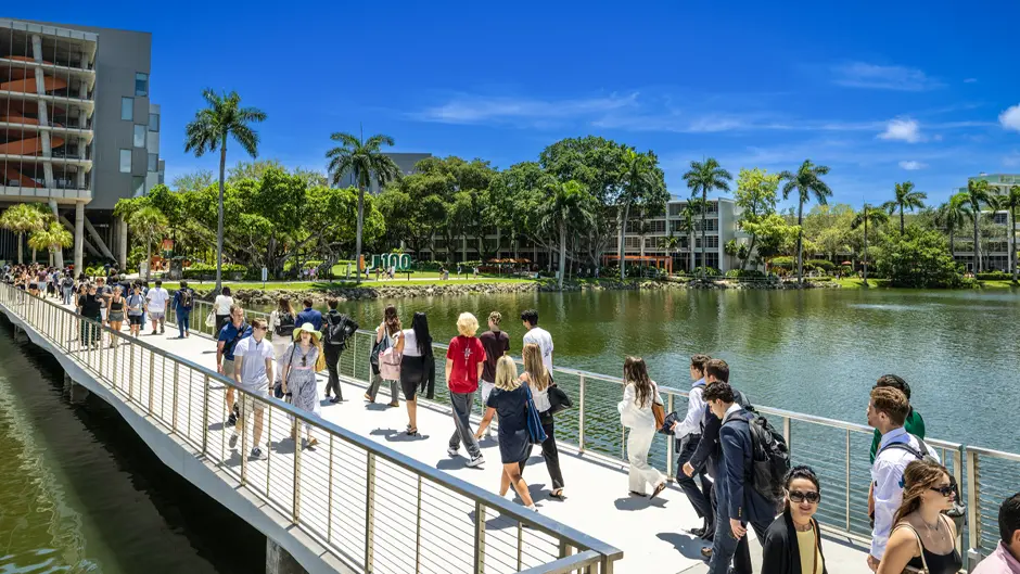 Students walk across the Fate Bridge on the Coral Gables Campus