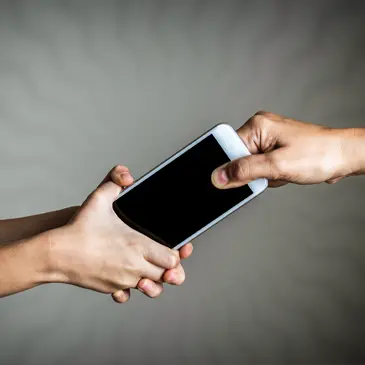 Stock image of hands fighting for a mobile device 