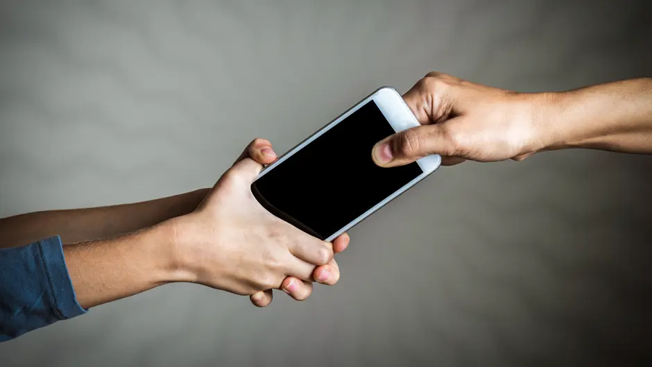 Stock image of hands fighting for a mobile device