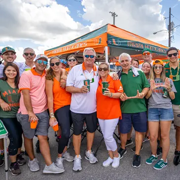 A group of Canes fans pose at a tailgate event 