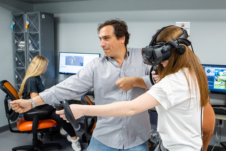 Professor Grinfeder works with student in the XR Lab.