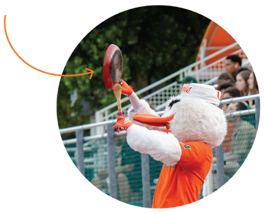 Sebastian at a Women's Soccer game, using a pan and wooden spoon as an instrument.