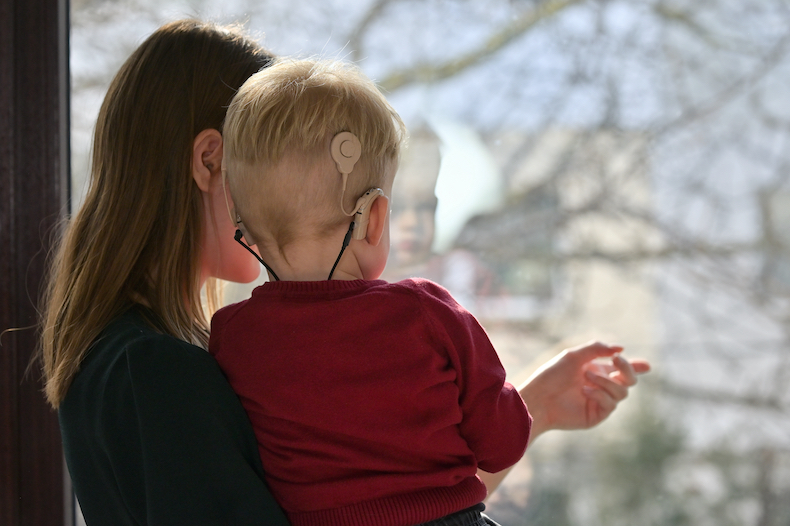 Child with cochlear implant and mother