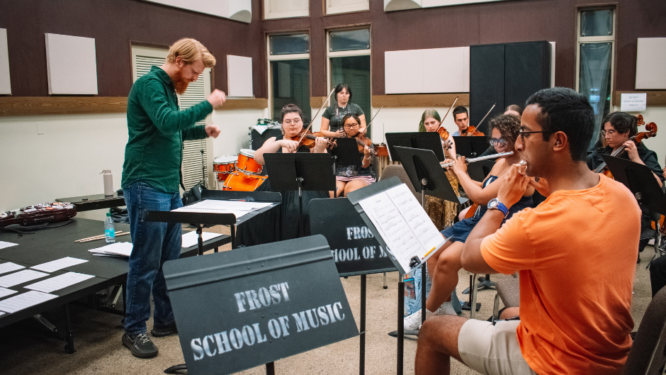 Student conductor Walker Klauda leads a Rock Symphonic orchestra rehearsal. photo izzi guzman