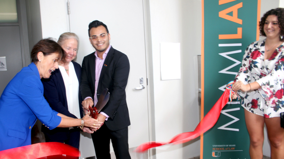 Cutting the ribbon in front of the new gender-neutral bathroom