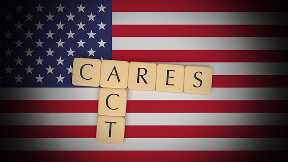 American Flag background with Cares Act spelled in scrabble tiles in foreground