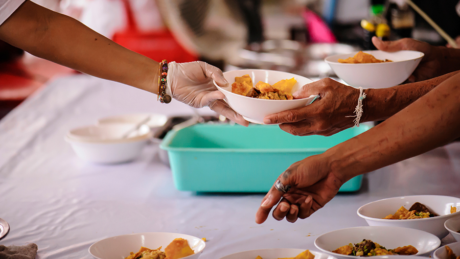 Volunteer serving food to people in need