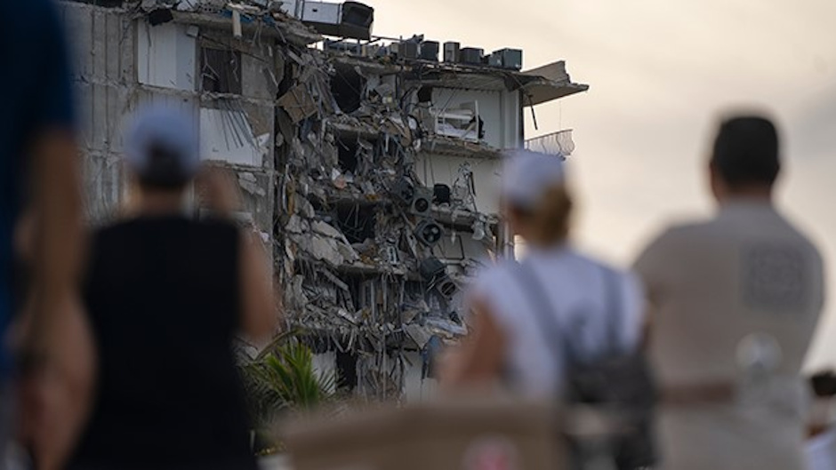 People looking at the collapsed ruins of surfside condo building